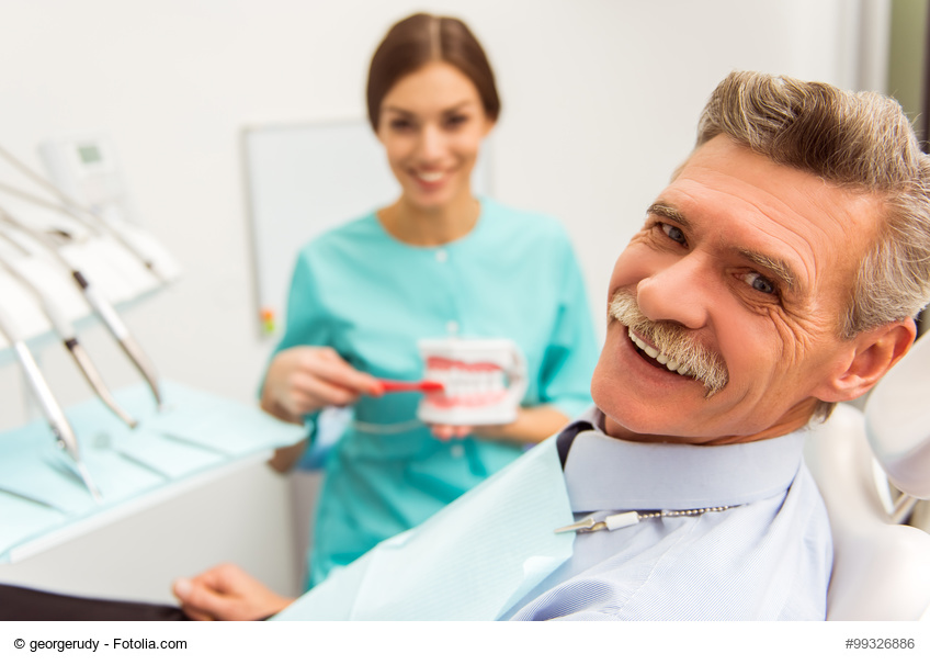 Mann und Zahnarzthelferin in der Zahnarztpraxis mit Zahnersatz und Pflege
